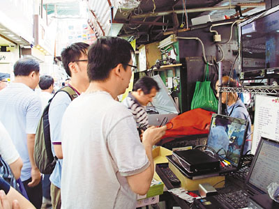 市民在鸭寮街排档，观购声称能从网上免费收看高清欧国杯直播的机顶盒。图片来源：香港文汇报